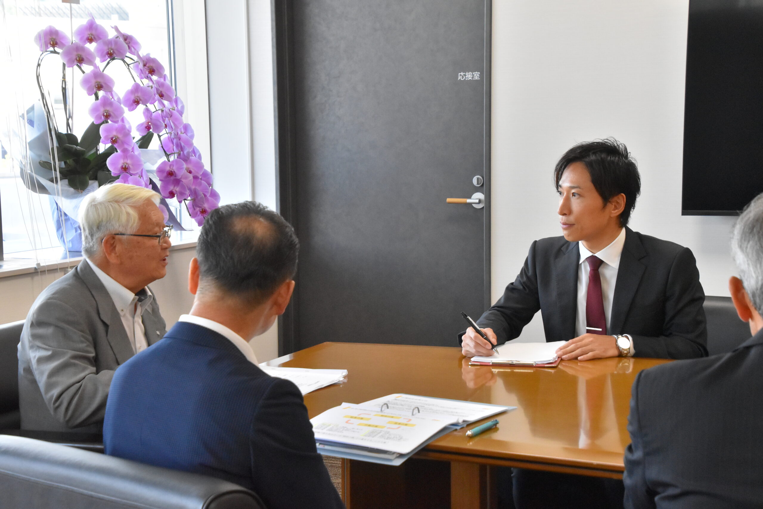 テーブルを囲み、講演後の面談で意見を交わす高畠町の出席者と滝沢雄太。
